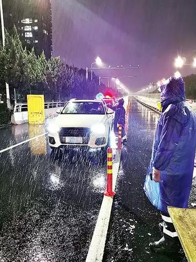 凌晨，东瓯大桥卡点处，永嘉县党员干部顶风冒雨、在严寒中牢牢值守。（　图片由浙江省温州市委组织部提供）