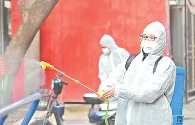 武汉市洪山区珞南街广八路社区书记对健身器械进行消毒。